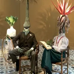 Mannequins aux têtes végétales dans l'espace Monte Cristo. Un enfant sur un tricycle, un couple lisant, un autre debout.