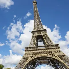 La Tour Eiffel se dresse fièrement sous un ciel bleu parsemé de nuages. Idéal pour savoir que faire autour de la Tour Eiffel.