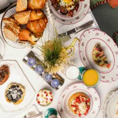 Un délicieux brunch parisien avec viennoiseries, tartines, pancakes aux fraises, et une tasse de café.