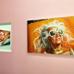 Une femme âgée aux cheveux blancs et lunettes de soleil extravagantes, sur une serviette orange vif. Une autre photo montre une main manucurée tenant une cigarette. Martin Parr expo.