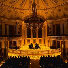 Concert de musique classique dans un théâtre parisien, illuminé par des milliers de bougies. Une scène magique de candlelight Paris.