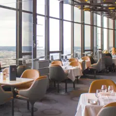 Vue panoramique depuis un restaurant du Tour Montparnasse à Paris. Tables dressées, vue sur la ville.
