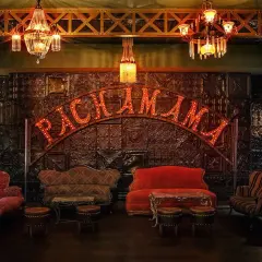 Ambiance feutrée au Pachamama Paris. Canapés vintage, luminaires scintillants et enseigne lumineuse pour un avis mémorable.