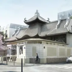 La Pagode à Paris, un bâtiment aux toits courbés, se dresse fièrement dans une rue bordée d'arbres fleuris et de bâtiments haussmanniens.