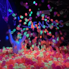 Des balles fluorescentes pleuvent sur des enfants dans une piscine à balles colorée. Une expérience sensas Paris inoubliable.