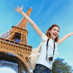 Joyeuse touriste avec appareil photo devant la Tour Eiffel. Un bon plan Paris pour des souvenirs inoubliables !