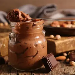 Une cuillère de mousse au chocolat parisienne, onctueuse et gourmande, sur fond de chocolat noir et noisettes.