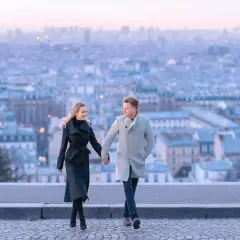 Un couple se promène main dans la main, avec Paris en arrière-plan. Un spot photo parisien parfait pour immortaliser un moment romantique.