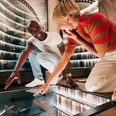 Un couple s'émerveille devant une installation interactive dans un musée des paradoxes.