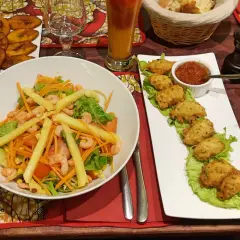 Un festin dans un restaurant antillais : salade de crevettes, accras, bananes plantain frites et un cocktail rafraîchissant.