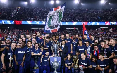 L'équipe célèbre sa victoire au Parc des Princes, soulevant des trophées sous les acclamations de la foule.