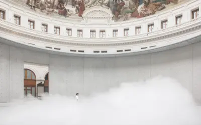 Un homme seul dans un nuage de vapeur au centre de la rotonde de la **Fondation Pinault Paris**, sous une fresque monumentale.