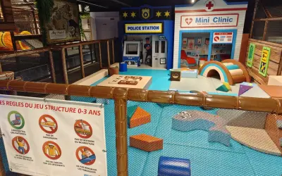 Aire de jeu pour enfants à Paris avec une station de police, une mini-clinique et des structures ludiques. Sept carrés colorés pour le jeu.