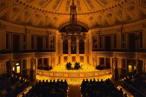 Concert de musique classique dans un théâtre parisien, illuminé par des milliers de bougies. Une scène magique de candlelight Paris.