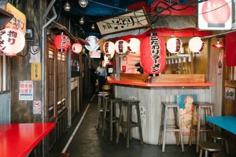 Ambiance de resto japonais à Paris, avec lanternes rouges et enseignes typiques.