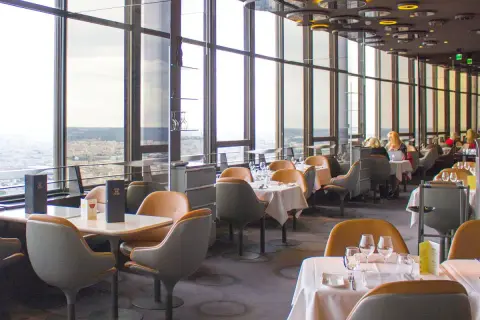 Vue panoramique depuis un restaurant du Tour Montparnasse à Paris. Tables dressées, vue sur la ville.