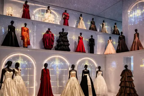 Élégantes robes de haute couture sur mannequins, une **exposition mode Paris** féerique sous un ciel étoilé.