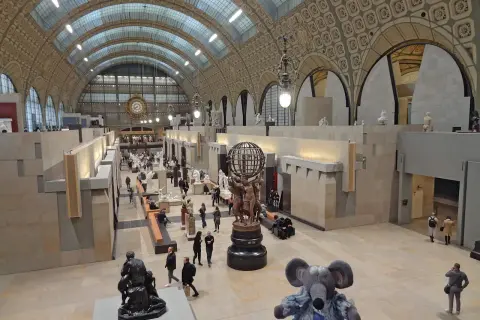 Vue panoramique du musée d'Orsay à Paris, avec ses vastes salles d'exposition, ses sculptures et ses visiteurs.