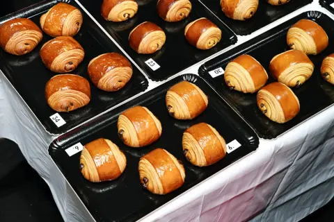Des pains au chocolat dorés et feuilletés, certains numérotés, prêts à être dégustés. Le meilleur pain au chocolat de Paris se trouve peut-être ici !