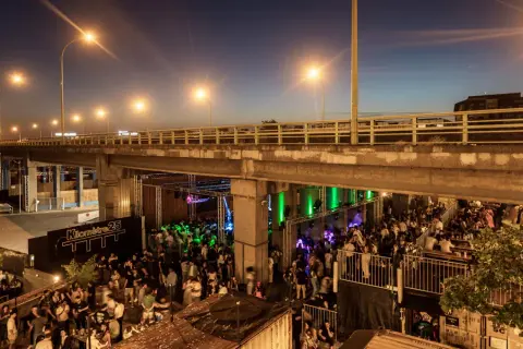 Soirée animée sous un pont, avec une foule dansant et profitant de la musique au Kilomètre 25.