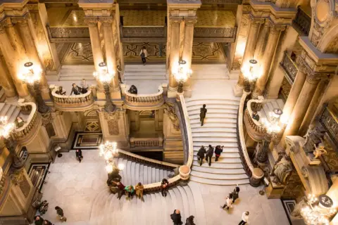 Magnifique escalier de l'Opéra Garnier. Visite gratuite pour admirer cette architecture somptueuse et ses lustres étincelants.