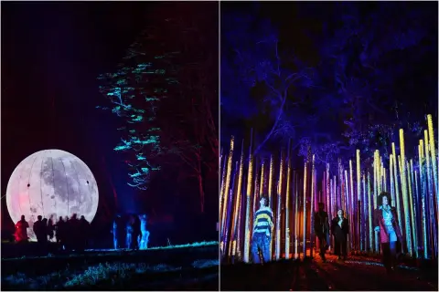 Un parcours lumineux à Paris, avec une lune géante illuminée et une forêt de piliers colorés. L'ambiance est féerique.