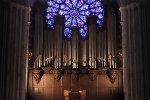 L'orgue majestueux de Notre-Dame, une vision éternelle, se dresse sous la rosace aux vitraux éclatants.