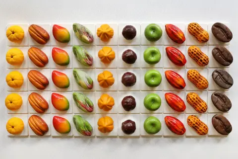 Assortiment de chocolats aux formes fruitées et originales, rappelant l'univers de Cédric Grolet. Des mangues, citrons, cacahués, fèves de cacao et autres délices.