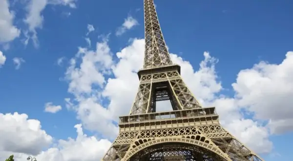 La Tour Eiffel se dresse fièrement sous un ciel bleu parsemé de nuages. Idéal pour savoir que faire autour de la Tour Eiffel.