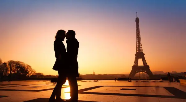 Un couple s'embrasse au coucher du soleil à Paris, une idée date romantique parfaite.