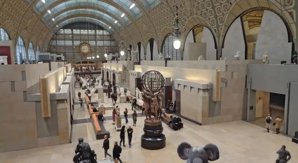 Vue panoramique du musée d'Orsay à Paris, avec ses vastes salles d'exposition, ses sculptures et ses visiteurs.