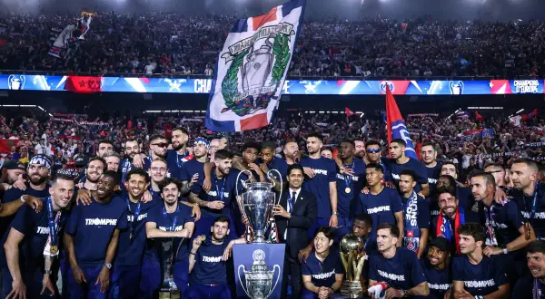 L'équipe célèbre sa victoire au Parc des Princes, soulevant des trophées sous les acclamations de la foule.