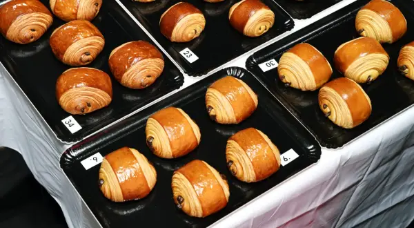 Des pains au chocolat dorés et feuilletés, certains numérotés, prêts à être dégustés. Le meilleur pain au chocolat de Paris se trouve peut-être ici !