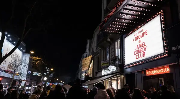 Une foule attend devant le Jamel Comedy Club à Paris pour une soirée de stand-up.