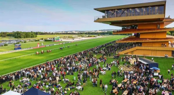 Ambiance festive à l'hippodrome de ParisLongchamp pour les jeuxdi. Une foule nombreuse profite de l'événement sur l'herbe, sous le soleil.