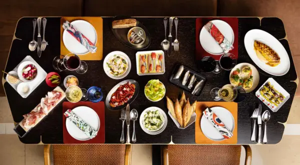 Un festin de tapas et de charcuterie sur une table de restaurant Paul Pairet.