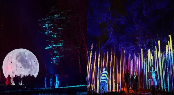 Un parcours lumineux à Paris, avec une lune géante illuminée et une forêt de piliers colorés. L'ambiance est féerique.