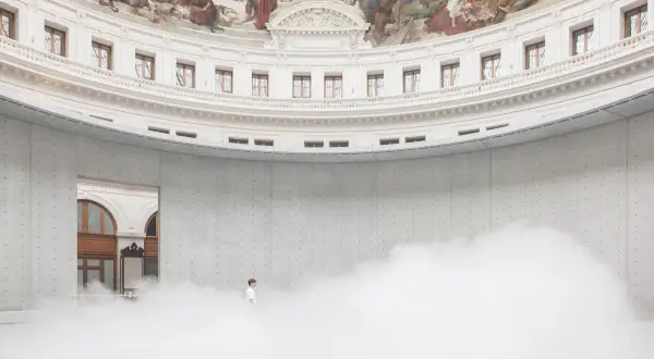 Un homme seul dans un nuage de vapeur au centre de la rotonde de la **Fondation Pinault Paris**, sous une fresque monumentale.