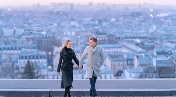 Un couple se promène main dans la main, avec Paris en arrière-plan. Un spot photo parisien parfait pour immortaliser un moment romantique.