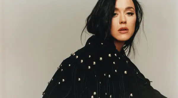 Katy Perry, vêtue d'une veste noire cloutée, pose avec intensité, évoquant le glamour de Paris.