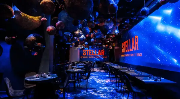 Décoration de restaurant "STELLAR" avec des planètes suspendues, évoquant un voyage **éphemère stellaire**. L'ambiance est cosmique et immersive.