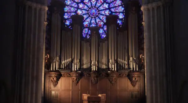 L'orgue majestueux de Notre-Dame, une vision éternelle, se dresse sous la rosace aux vitraux éclatants.