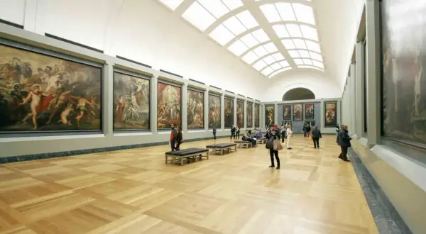 Vaste galerie d'art parisienne avec de grandes peintures et des visiteurs admirant l'expo gratuite.