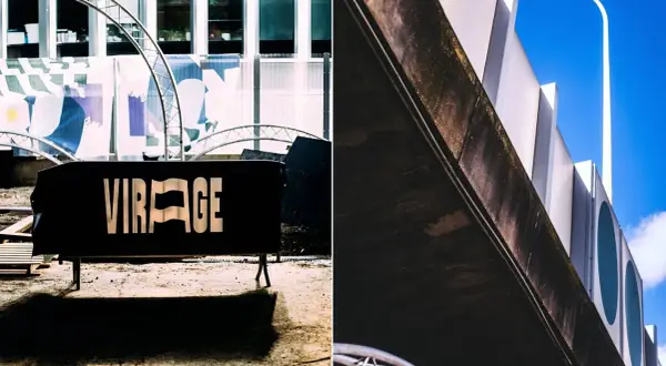 Panneau noir "VIRAGE" devant un bâtiment moderne. Le virage parisien est prêt.
