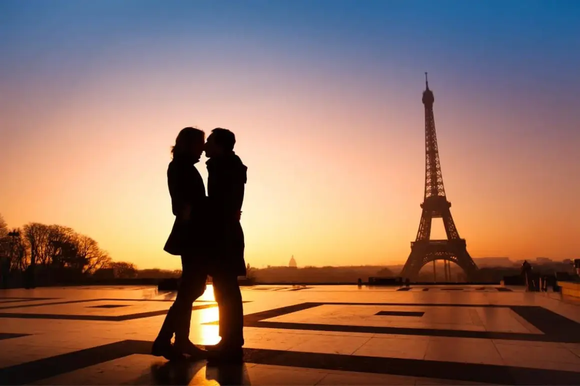 Un couple s'embrasse au coucher du soleil à Paris, une idée date romantique parfaite.