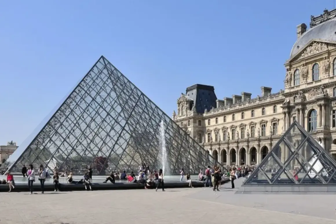 La pyramide du Louvre, un des musées ouverts le lundi, attire des visiteurs sous un ciel bleu.