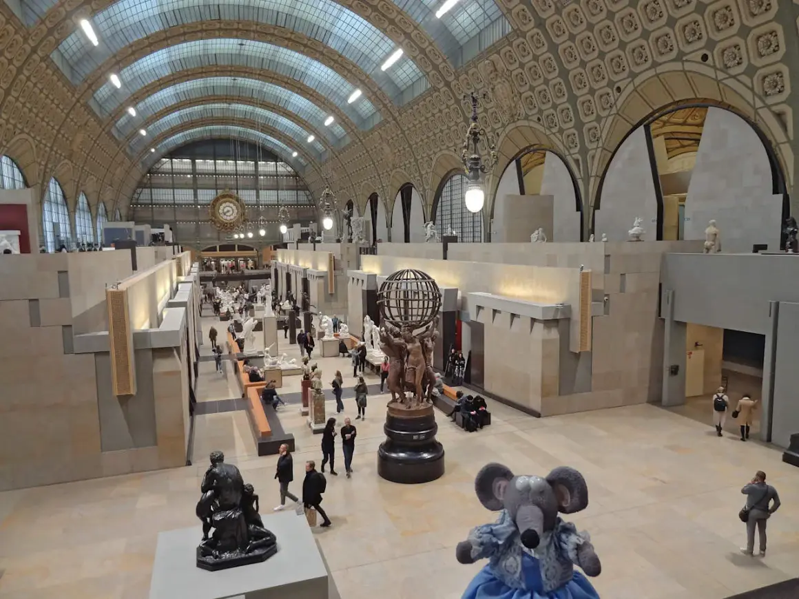 Vue panoramique du musée d'Orsay à Paris, avec ses vastes salles d'exposition, ses sculptures et ses visiteurs.