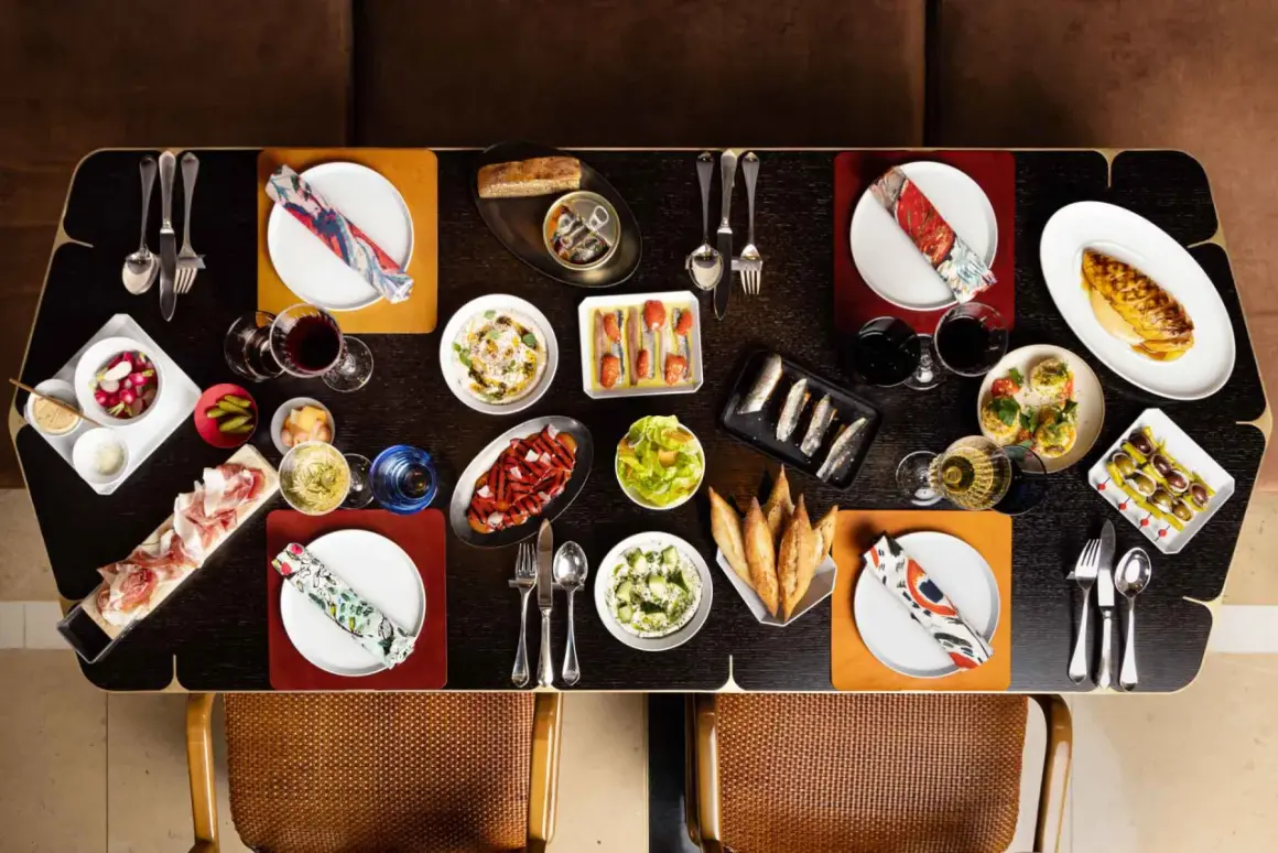 Un festin de tapas et de charcuterie sur une table de restaurant Paul Pairet.