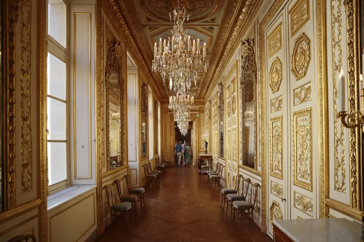 Un long couloir orné de dorures et de lustres étincelants, rappelant la splendeur du **hôtel de la Marine**.