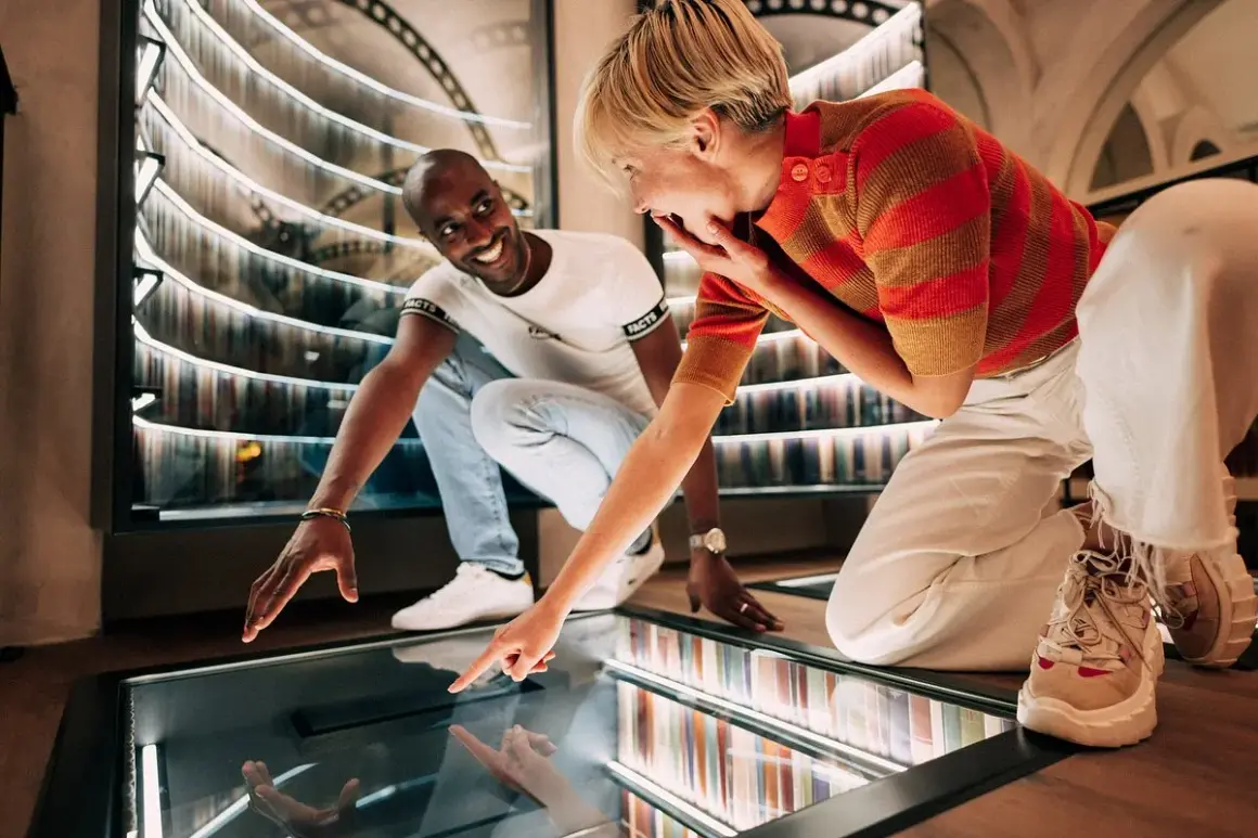 Un couple s'émerveille devant une installation interactive dans un musée des paradoxes.